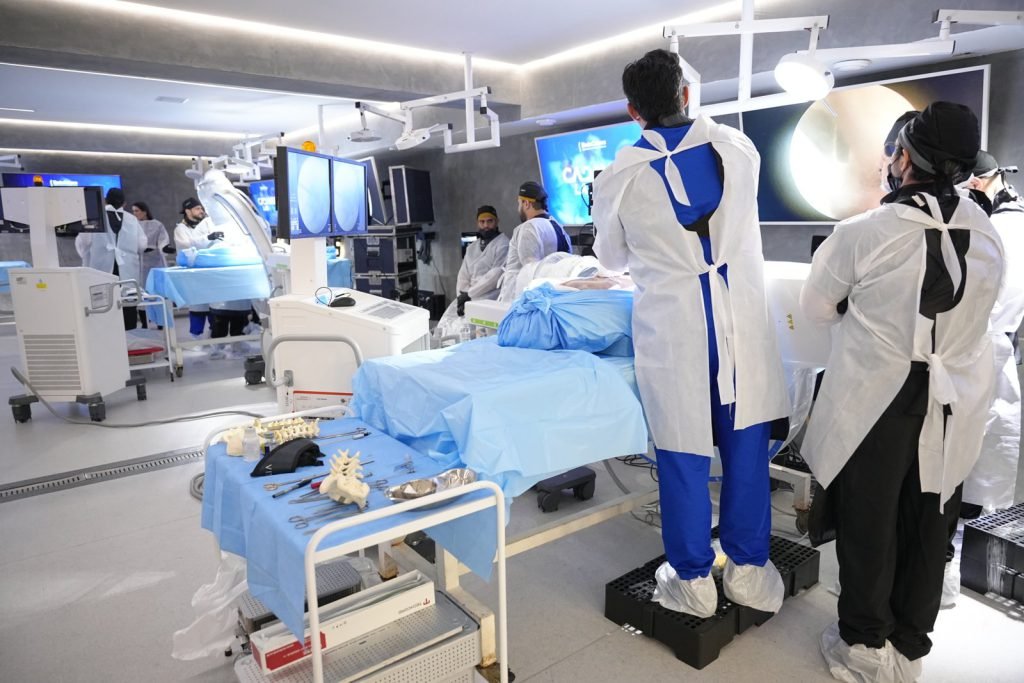 Laboratório do EndoColuna Cadaverlab com alunos nas estações de treinamento em cadáver fresco