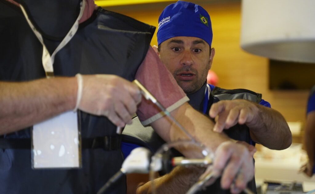 Instrutor orienta aluno no manuseio do endoscópio durante o Cadaverlab