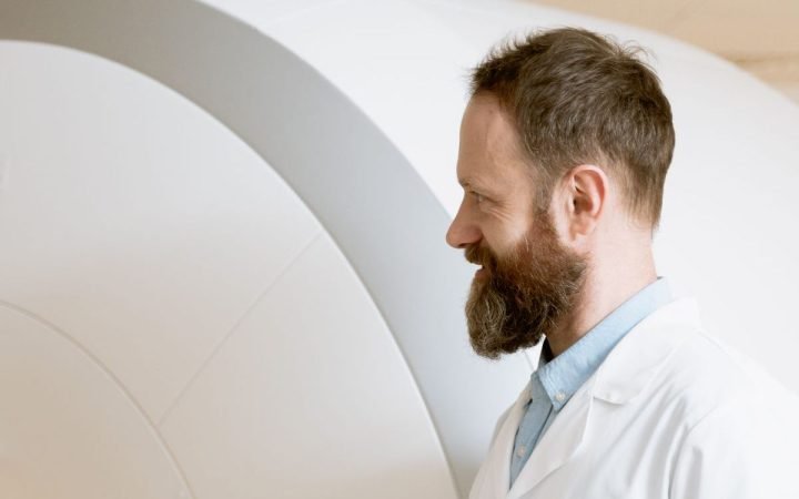 Médico ao lado de um aparelho de ressonância magnética